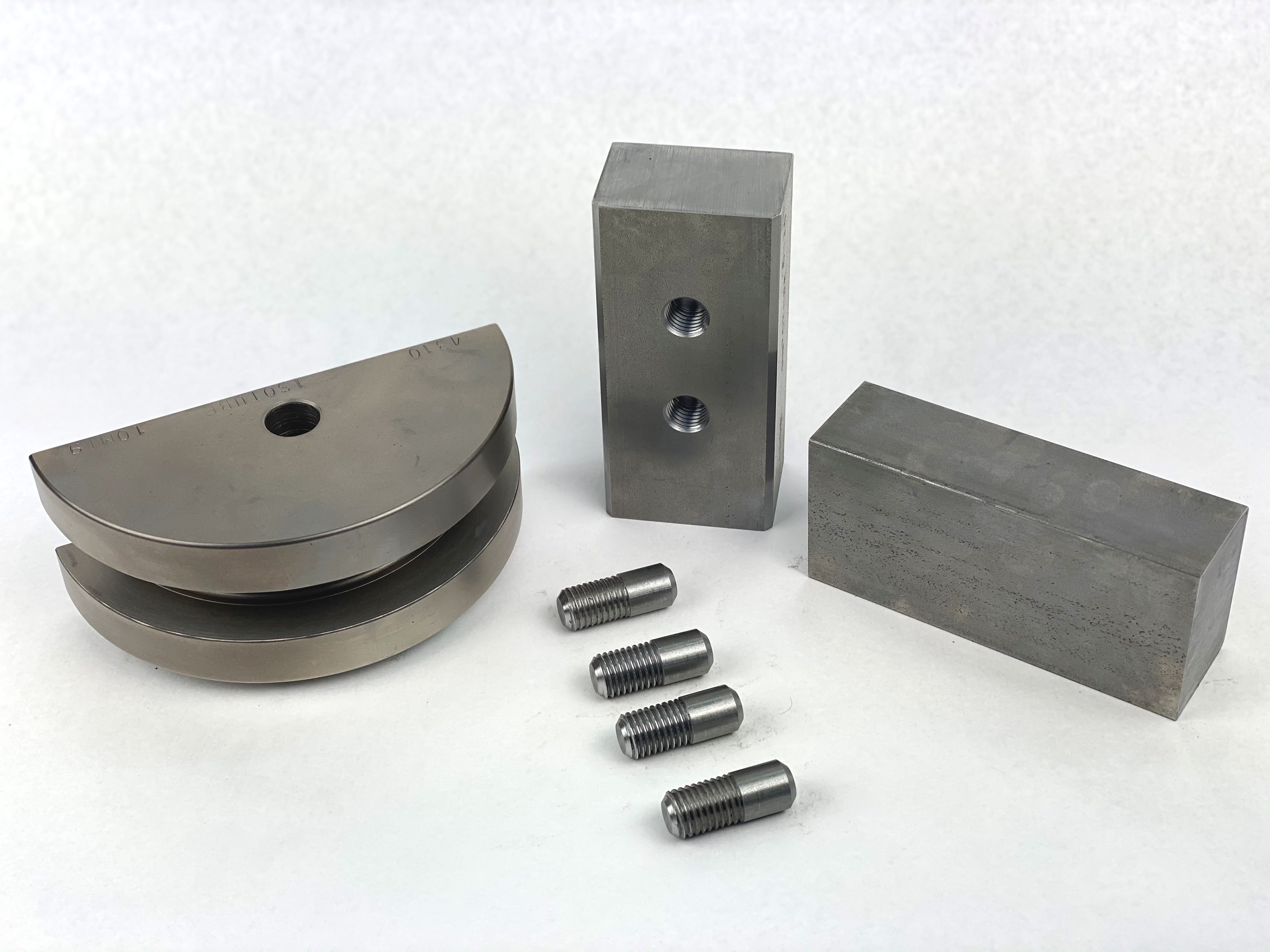 A set of square tooling by Huth-Ben Pearson for BendPak®️ machines. The tooling is grey steel and consists of several rectangular back shoes and a half-round die made to fit square pipe and tubing.